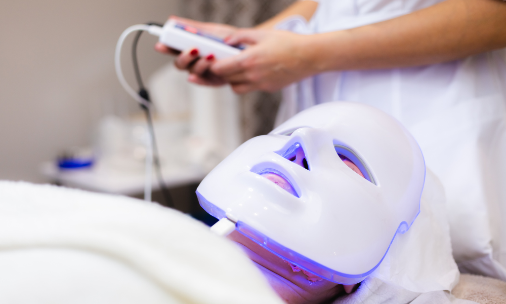 A person receiving a blue LED light therapy facial treatment.