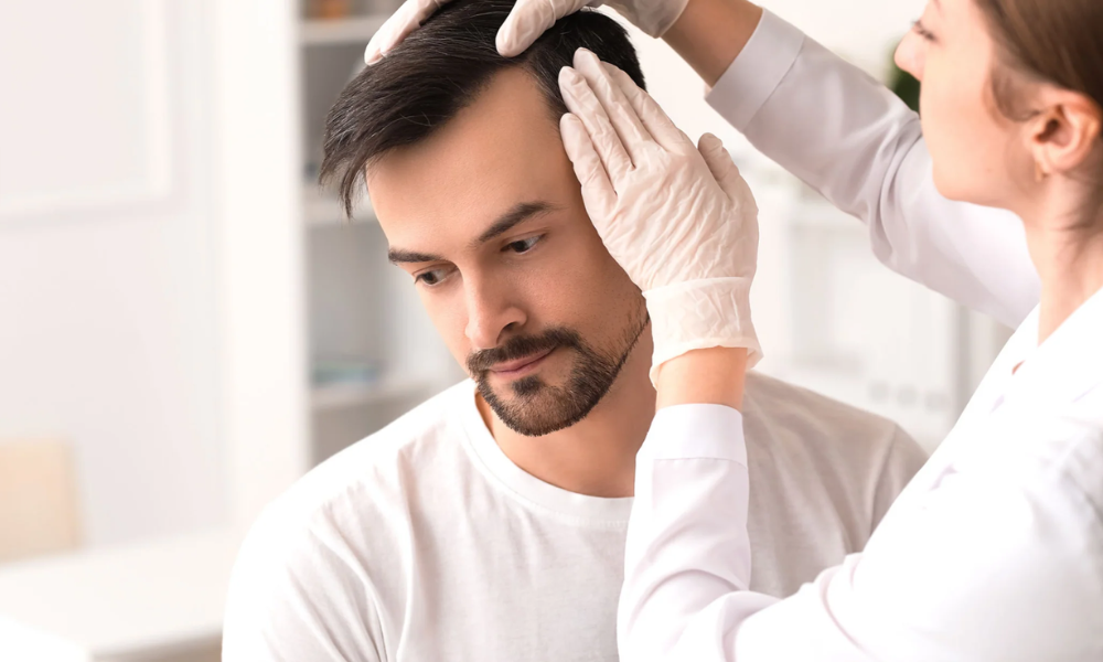 A male patient receiving a hair loss consultation from a female medical professional.