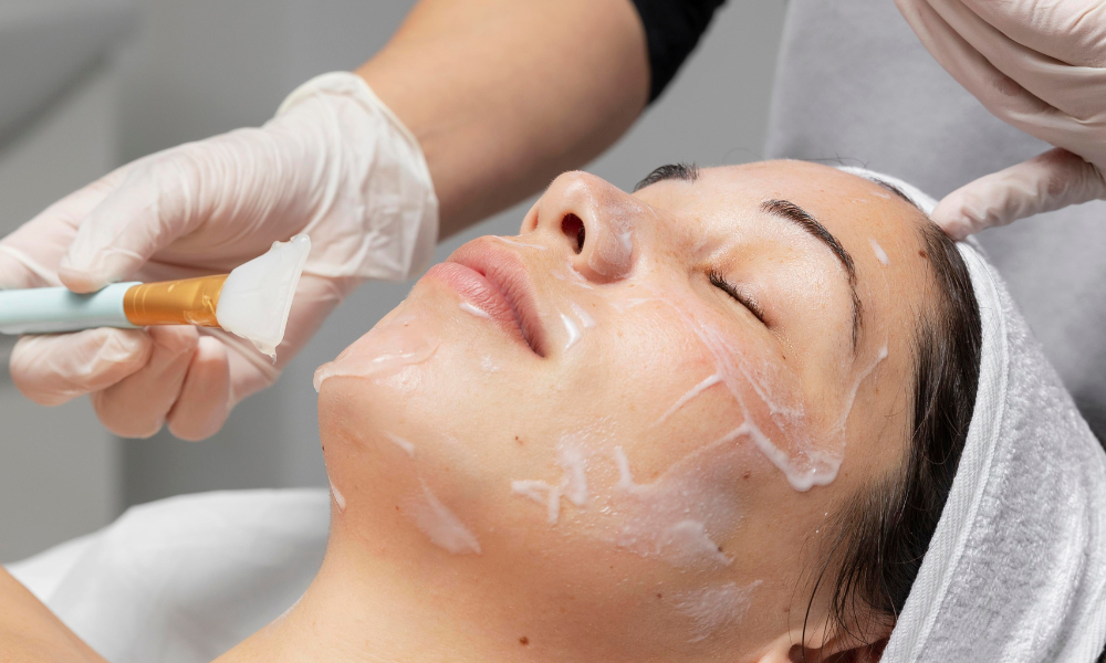A woman receiving a facial treatment with a brush application.